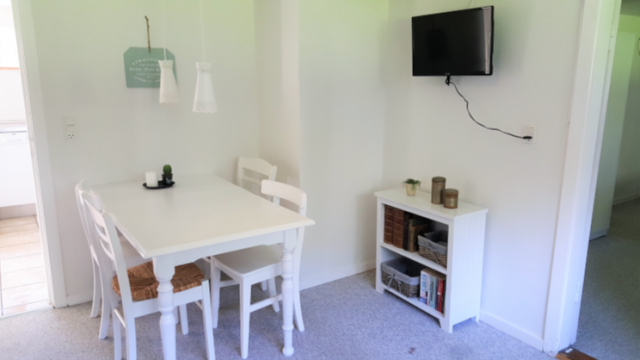 Opholdsstue med TV, sofa og spiseplads